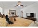 Bright main bedroom with a ceiling fan, dresser, mirror, TV, and door to the main bathroom at 3925 Ne 58Th Cir, Silver Springs, FL 34488