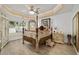 Elegant main bedroom featuring a four-poster bed, tray ceilings, and ample closet space at 3925 Ne 58Th Cir, Silver Springs, FL 34488