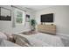 Comfortable bedroom featuring a dresser, TV, large window, and neutral color palette at 5095 Sw 158Th St, Ocala, FL 34473