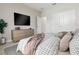 Modern bedroom with a minimalist style, featuring a dresser, TV, and neutral color palette at 5095 Sw 158Th St, Ocala, FL 34473