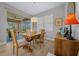 Bright dining room featuring a wooden table, tan cushioned chairs, and sliding glass doors to a patio at 6185 Sw 89Th Ct, Ocala, FL 34481