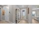 Inviting hallway with wood-look tile, decorative shelving and a leaded glass front door at 6185 Sw 89Th Ct, Ocala, FL 34481