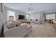 Bright living room with two sofas, neutral tones, a ceiling fan, and a large decorative rug connected to the dining area at 6185 Sw 89Th Ct, Ocala, FL 34481