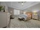 Bright, neutral-toned main bedroom with a tray ceiling, dresser, and a cozy sitting area at 6185 Sw 89Th Ct, Ocala, FL 34481