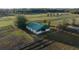 Elevated view highlights the barn featuring a green roof, and white walls at 6890 Nw 21St St, Ocala, FL 34482