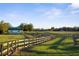 Quaint barn nestled in a green pasture with wooden fencing, showcasing a harmonious blend of rural charm and functionality at 6890 Nw 21St St, Ocala, FL 34482