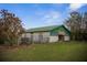 Exterior shot of barn featuring a green roof, stalls, and adjacent pasture at 6890 Nw 21St St, Ocala, FL 34482