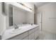 Bright bathroom featuring double sinks with white vanities, a large mirror, and tiled floors at 6890 Nw 21St St, Ocala, FL 34482