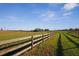 A rustic fence with long shadows runs alongside the property, bordering green fields at 6890 Nw 21St St, Ocala, FL 34482