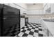 Kitchen features checkerboard floors, white cabinets, and black appliances at 6890 Nw 21St St, Ocala, FL 34482