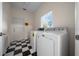 Laundry room with checkerboard floors, washer, dryer and natural light at 6890 Nw 21St St, Ocala, FL 34482