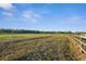 Expansive green pasture with post and rail fencing under a blue sky, ideal for equestrian activities at 6890 Nw 21St St, Ocala, FL 34482