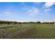 Scenic view of expansive pasture land featuring wooden fencing and mature trees under a blue sky at 6890 Nw 21St St, Ocala, FL 34482