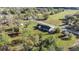 Aerial view of the home with a long driveway set on a grassy lot surrounded by trees at 7010 Nw 44Th Ave, Ocala, FL 34482