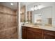 Bathroom with tiled walk-in shower with bench and dark wood vanity at 7010 Nw 44Th Ave, Ocala, FL 34482