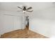 Bedroom with wood floors, ceiling fan, closet, and door to the bathroom at 7010 Nw 44Th Ave, Ocala, FL 34482