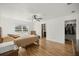 Bright bedroom with wood floors, a ceiling fan, and an ensuite bathroom and closet at 7010 Nw 44Th Ave, Ocala, FL 34482