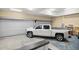 Spacious garage featuring two roll-up doors and a white pickup truck parked inside at 7010 Nw 44Th Ave, Ocala, FL 34482