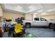 Well-lit garage featuring a white pickup truck, lawn mower, and other equipment at 7010 Nw 44Th Ave, Ocala, FL 34482