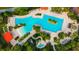 Aerial view of a resort style pool area with multiple pools, palm trees, umbrellas, lounge chairs and mature landscaping at 7151 Sw 96Th Ct, Ocala, FL 34481