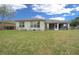 Grassy backyard featuring view of home's lanai and exterior with privacy fence at 7151 Sw 96Th Ct, Ocala, FL 34481