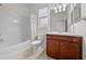 Bright bathroom featuring a shower-tub combo, neutral tile, wood vanity, and a large mirror at 7151 Sw 96Th Ct, Ocala, FL 34481