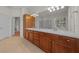 Bathroom showcasing double sink vanity and view to shower and entry hall at 7151 Sw 96Th Ct, Ocala, FL 34481