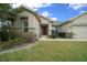 Inviting home exterior with a well-kept lawn, charming shrubbery, and a welcoming front entrance at 7151 Sw 96Th Ct, Ocala, FL 34481