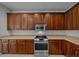 Kitchen features stainless steel microwave and range oven with wood cabinets and tan countertops at 7151 Sw 96Th Ct, Ocala, FL 34481