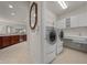 Bright laundry room with a washer, dryer, sink and ample cabinet space for convenient storage at 7151 Sw 96Th Ct, Ocala, FL 34481