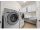 This laundry room features updated appliances, tile floor, storage cabinets and sink at 7151 Sw 96Th Ct, Ocala, FL 34481