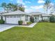 Attractive single-story home with a lush green lawn, mature landscaping, and a two-car garage at 7340 Sw 111Th Ln, Ocala, FL 34476