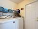 Laundry room with a washer, dryer, and shelving, offering efficient organization at 7340 Sw 111Th Ln, Ocala, FL 34476