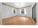 Sunlit living room featuring wood floors, white walls, and access to the backyard at 7810 Sw 186Th Cir, Dunnellon, FL 34432