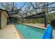 Enclosed pool featuring a full screen enclosure, a pool ladder, and ample lounge space at 7810 Sw 186Th Cir, Dunnellon, FL 34432