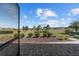 Picturesque backyard view from the screened-in patio with lush green lawn and blue skies at 8719 Sw 76Th Street Rd, Ocala, FL 34481