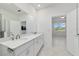 Well-lit bathroom showcasing double sinks, white cabinetry, and a glass-enclosed shower at 8719 Sw 76Th Street Rd, Ocala, FL 34481