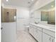 Modern bathroom with a glass-enclosed shower, white cabinets, and a large mirror at 8719 Sw 76Th Street Rd, Ocala, FL 34481