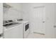 Laundry room showcases white washer and dryer, wire shelving, and a white door at 8719 Sw 76Th Street Rd, Ocala, FL 34481