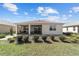 Well-manicured rear exterior view of the home featuring a covered patio and lush green lawn at 8719 Sw 76Th Street Rd, Ocala, FL 34481