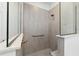 Close-up of a glass enclosed shower with beige tile, a shower head, and a grab bar for safety at 8719 Sw 76Th Street Rd, Ocala, FL 34481