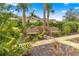 Tranquil backyard featuring two wooden benches, palm trees, and lush greenery at 8861 Sw 63Rd Ct, Ocala, FL 34476