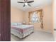 This bedroom has carpet, a floral bedspread, lamp, ceiling fan, and a window with curtains at 8861 Sw 63Rd Ct, Ocala, FL 34476