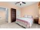 This carpeted bedroom has a bed with floral bedding, and a bookcase with adjacent closet at 8861 Sw 63Rd Ct, Ocala, FL 34476