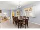 This dining room features a chandelier, wood table and chairs, and sliders to the exterior at 8861 Sw 63Rd Ct, Ocala, FL 34476