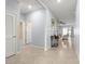 Hallway showcasing neutral tiled flooring and light blue walls leading into a living room with a ceiling fan at 8861 Sw 63Rd Ct, Ocala, FL 34476