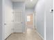 Hallway with neutral tiled flooring and light blue walls leading into a bedroom with neutral walls at 8861 Sw 63Rd Ct, Ocala, FL 34476