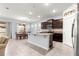 Bright open kitchen featuring an island, dark cabinetry, stainless appliances, and an adjacent dining area at 8861 Sw 63Rd Ct, Ocala, FL 34476