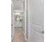 Bright hallway view of a bathroom with white cabinets, gray walls, and a decorative display shelf at 8864 Sw 85Th Loop, Ocala, FL 34481