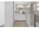 Hallway view of a bright bathroom featuring white cabinets, gray walls, and a tiled glass shower at 8864 Sw 85Th Loop, Ocala, FL 34481